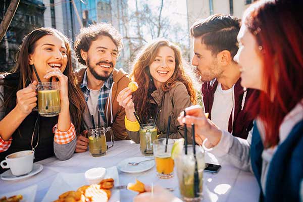 Group of friends eating and laughing at a cafe